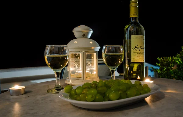 Bottle of wine and grapes on table