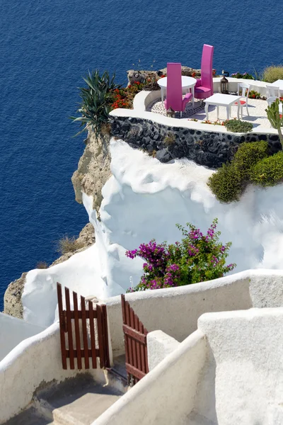Two purple chairs on balcony of Santorini  island cliff