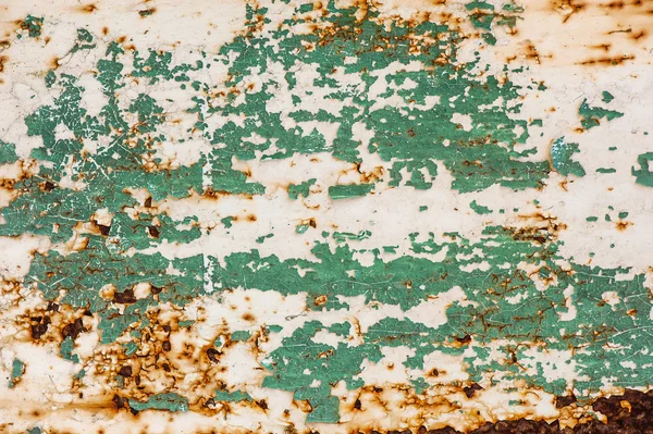 Cracked paint on rusty metal surface