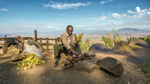 African man in a suit sells corn  near the Great Rift Valley in