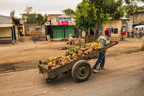 African man pulling a cart full of fruit