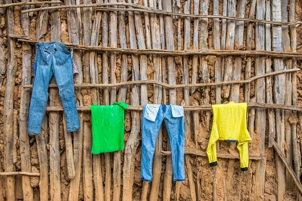 Clothes hanging on wall of a wooden hut in Africa