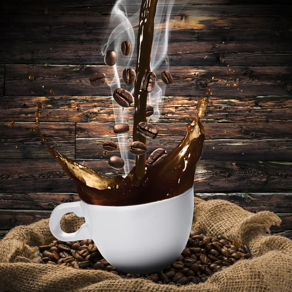 Coffee beans falling in Hot Coffee Cup