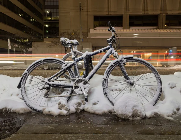 Bike at night covered in snow