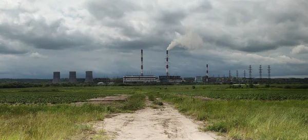 Image of factory in the middle of a green meadow on a cloudy day