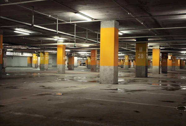 Image of parking garage underground interior, dark industrial bu