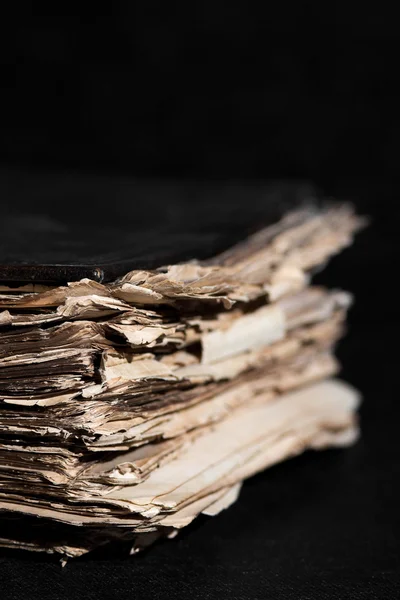 Old thick book on a black background on the desktop