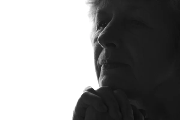 Black and white silhouette of a profile of an old woman on an isolated background