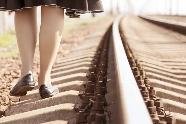 Girl walking on the tracks in the spring