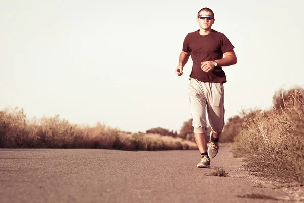 Young guy is engaged in jogging outdoors