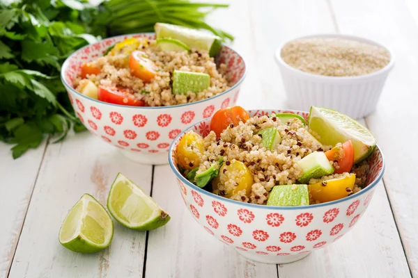 Quinoa salad in bowl on white wooden table