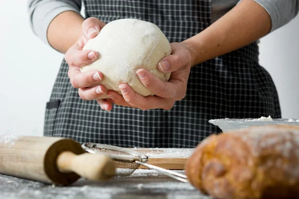 Woman making bread with her hand on wood table