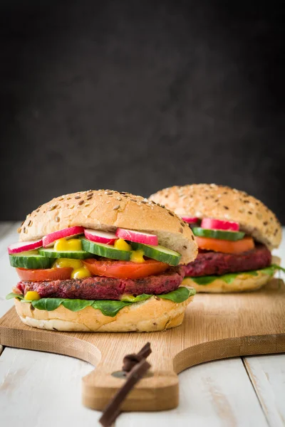 Veggie beet burger on white wooden table and slate background