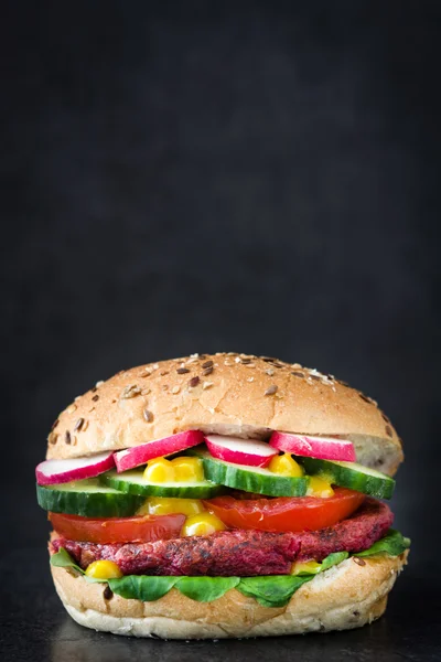 Veggie beet burger on black slate background