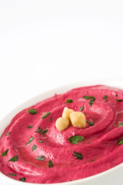 Beet hummus in a bowl isolated on white background