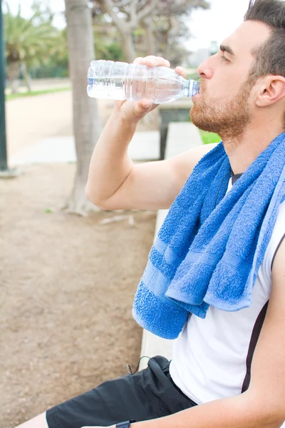 Man drinking water after exercise practice