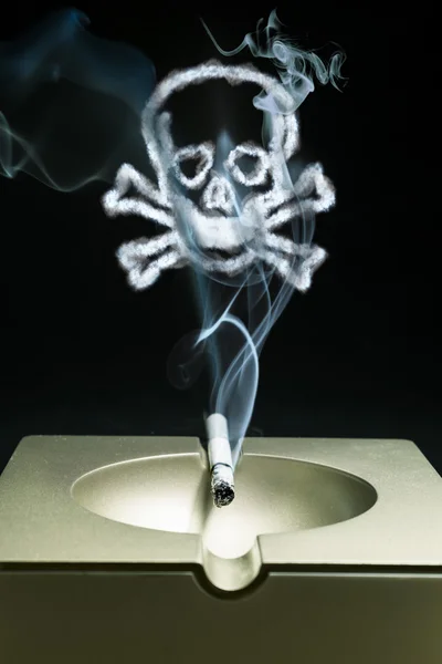 Smoldering cigarette in an ashtray with a smoke \