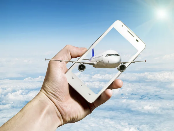 Airliner flying out of smartphone screen against cloudy landscap