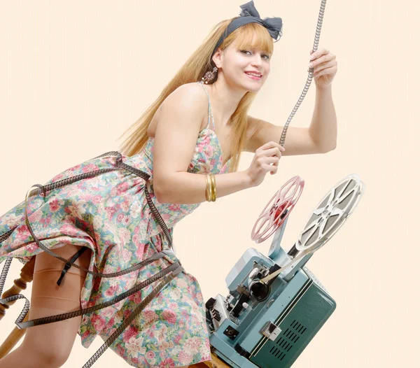 Sexy pin-up girl with film reel and vintage projector