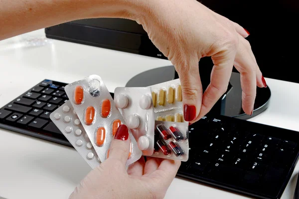 Businesswoman taking pills at workplace