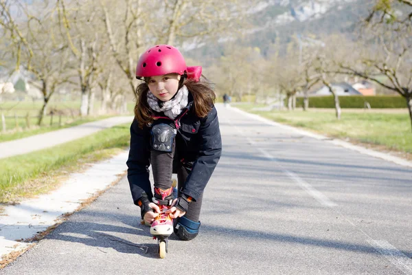 Pretty preteen girl on roller skates in helmet