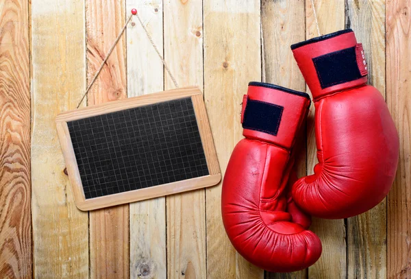 Pair of red boxing gloves with a chalkboard