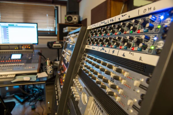 Several mixing consoles in a recording studio