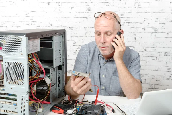 A technician repairing a computer and phone