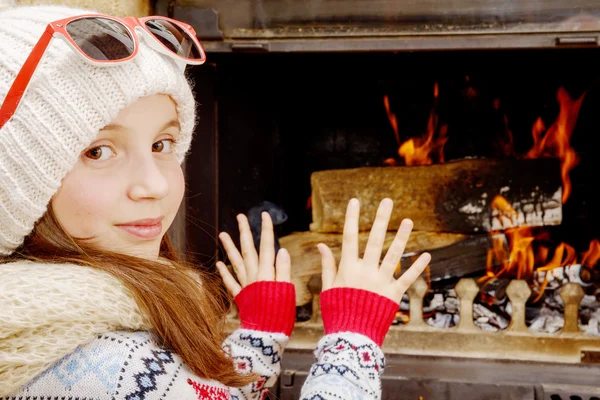 pretty young girl sitting near the fire place