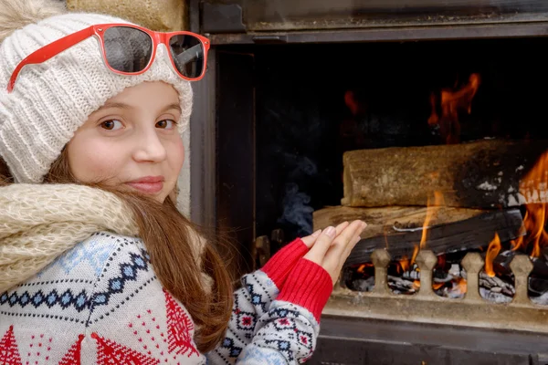 Winter at home,  pretty young girl sitting near the fire place