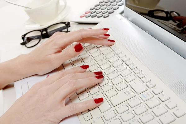 Female office worker typing on the keyboard