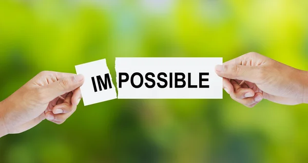 Businessman tearing the word Impossible for Possible