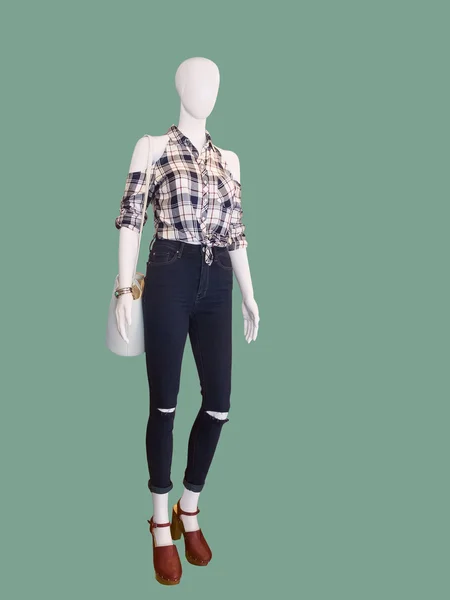 Female mannequin dressed in jeans and a checkered shirt.
