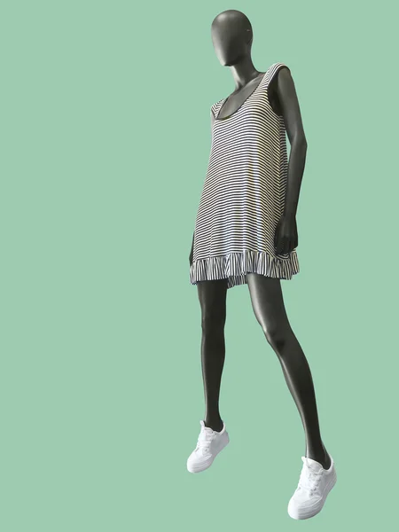 Female mannequin dressed in white stripped dress.