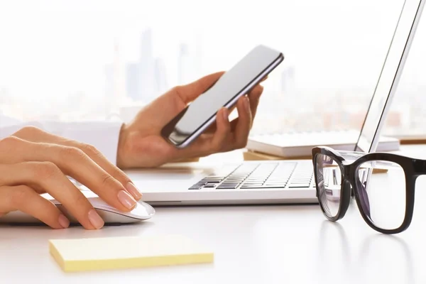 Female using phone and laptop