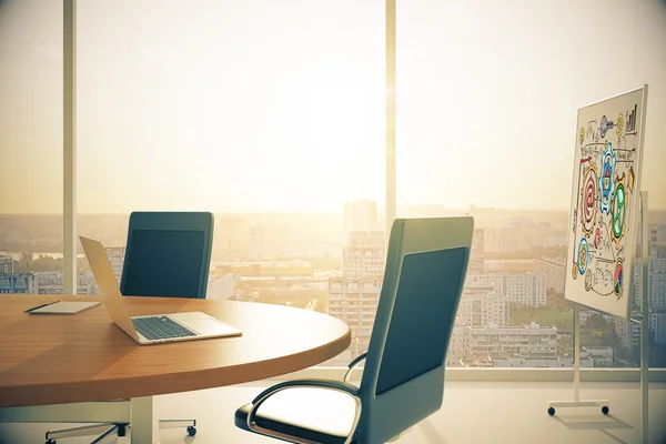 Sunny conference room with laptop and blackboard and city view
