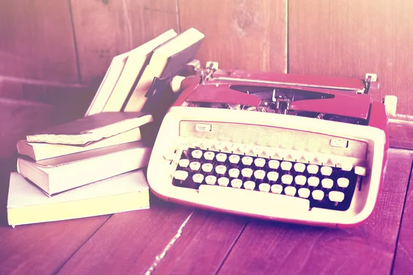 Old style typewriter and books on a wooden floor, instagram phot