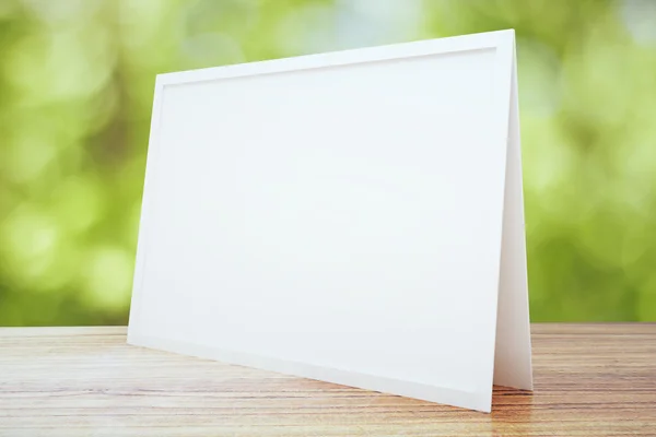 Blank white postcard on wooden table outdoor, mock up