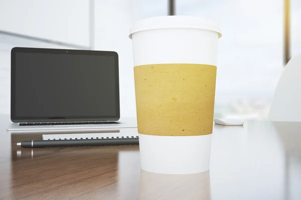 Blank paper cup of coffee on an office desk, mock up