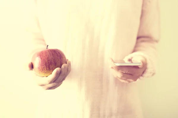 Girl with a cell phone and a red apple, education concept