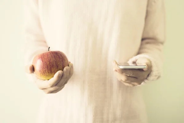 Girl with red apple and cell phone
