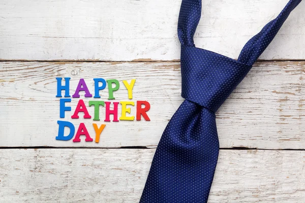 Happy fathers day sign and tie laid on wood