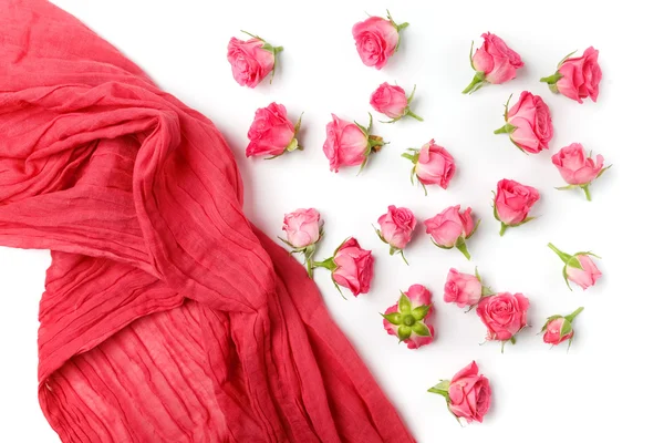 Assorted roses heads and scarf on white background. Overhead view. Flat lay