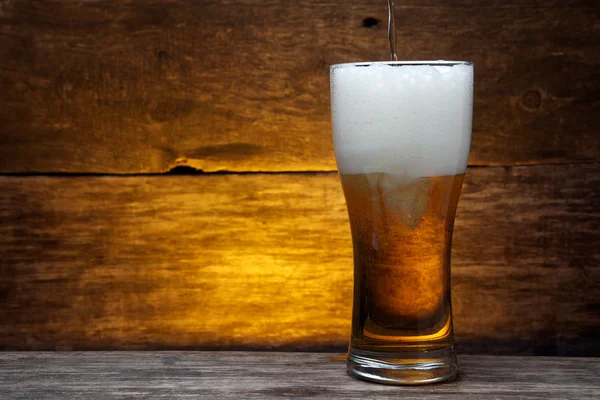 Glass of beer over vintage wood