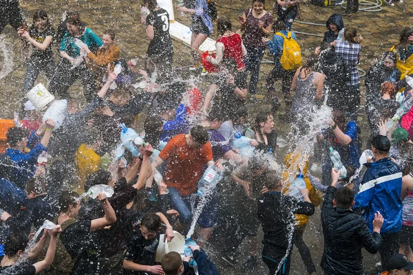 Happy boys & girls  pouring water on each other.