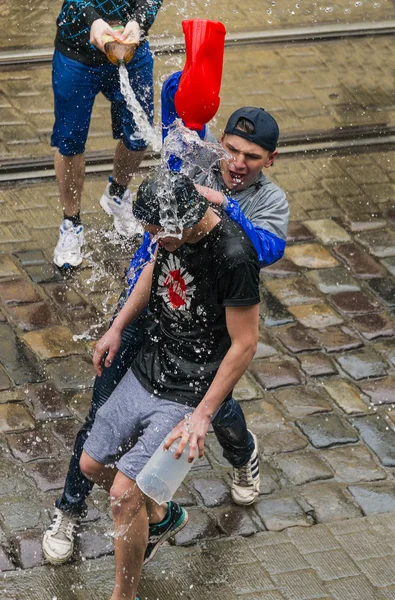 Happy boys  pouring water on each other.