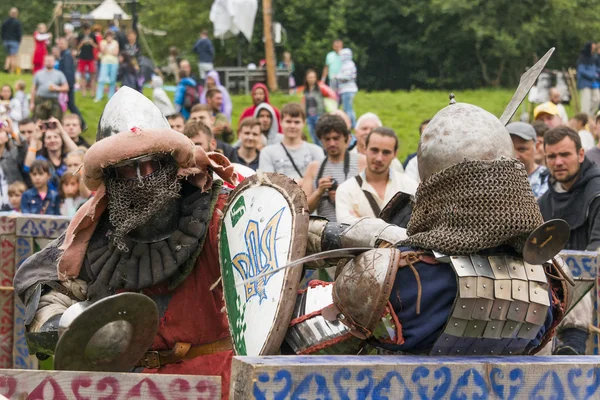 Participants of the festival in knight armor arrange fights