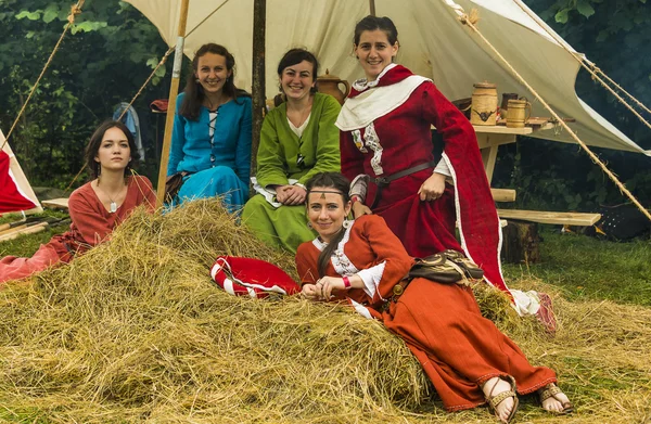 Girls   in medieval clothes relaxs on hay