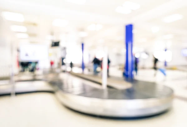 Abstract bokeh of conveyor belt at baggage claim sector area - Defocused background of international airport arrivals terminal gate - Travel concept and wanderlust business lifestyle