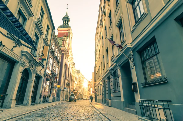 Vintage retro travel postcard of a narrow medieval street in old town Riga at sunset with sun reflection - Latvia - European capital of culture 2014